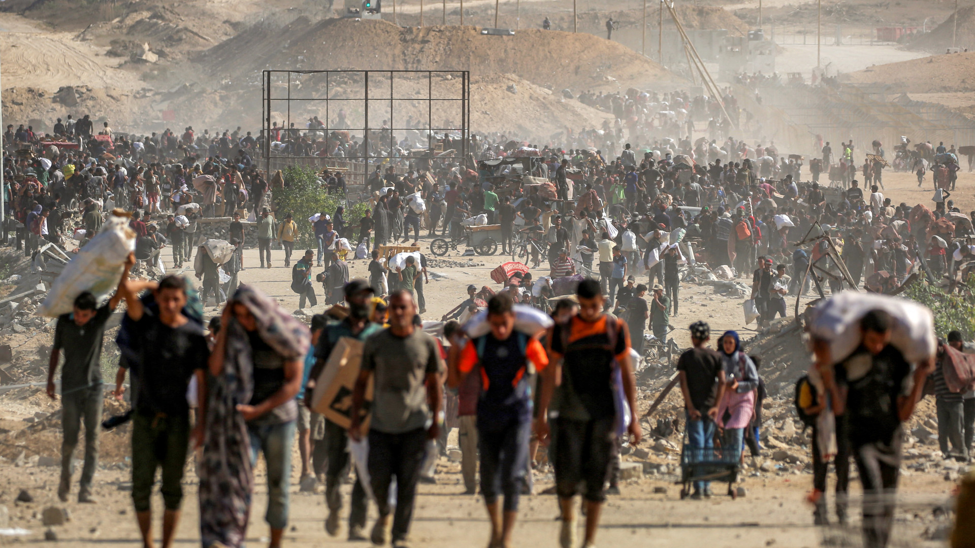 Palestinians carry aid packages from a distribution centre run by the US- and Israeli-backed Gaza Humanitarian Foundation (GHF), at the so-called 