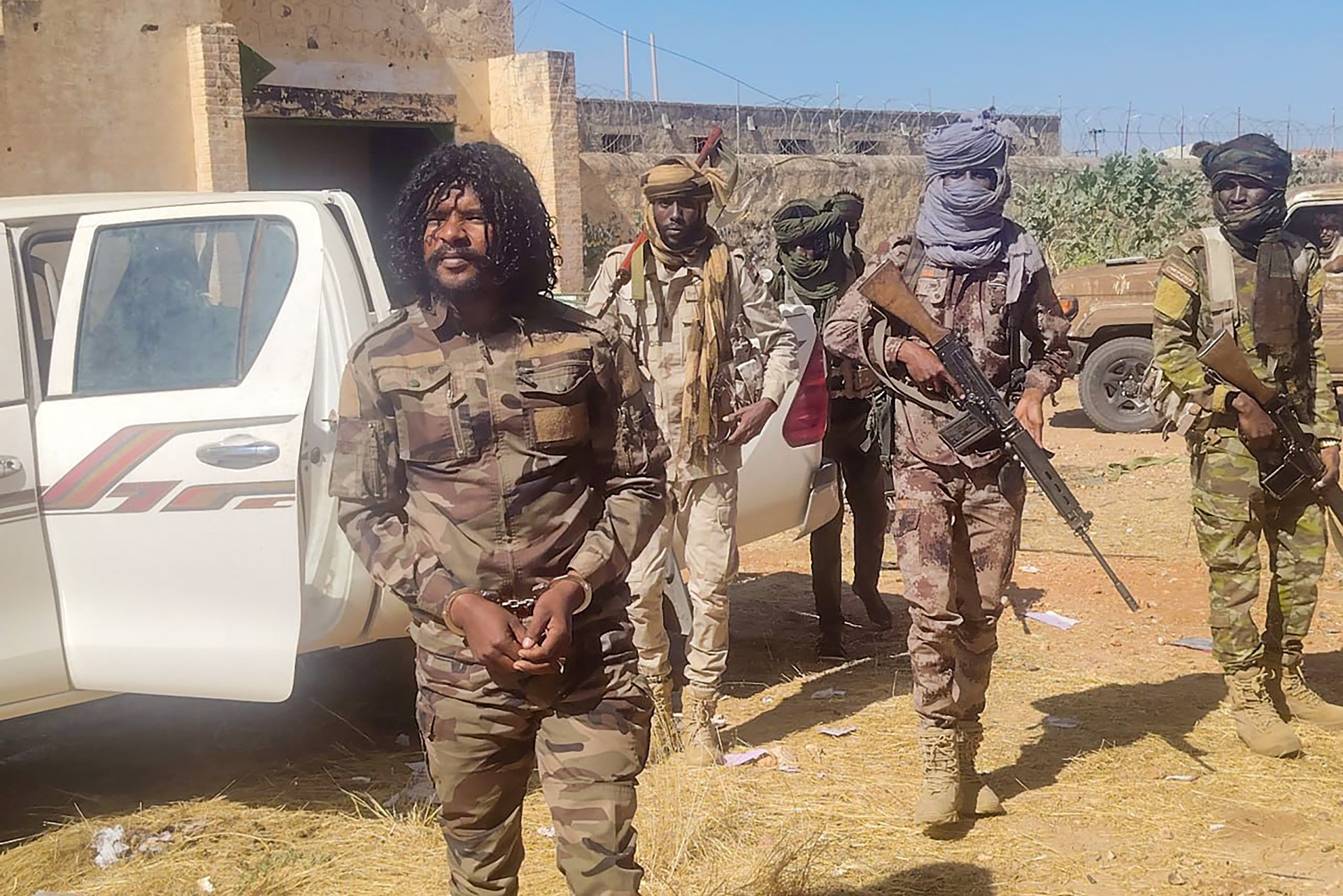 RSF members reportedly detaining a fighter known as Abu Lulu (L) in El-Fasher on 30 October 2025 (AFP/Rapid Support Forces handout)
