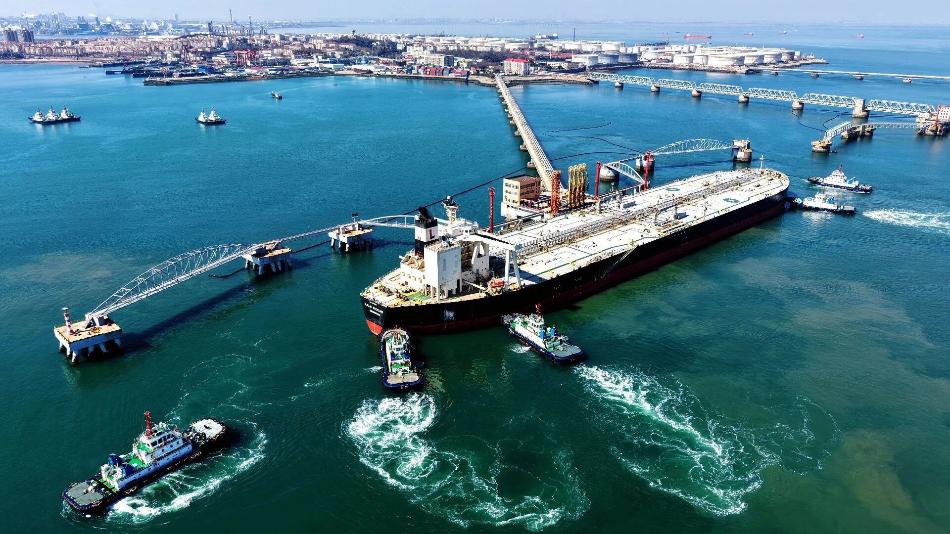 A crude oil tanker is guided to a berth at the oil terminal at the port in Qingdao, in China’s eastern Shandong province on 7 March 2026 (CN-STR/AFP)