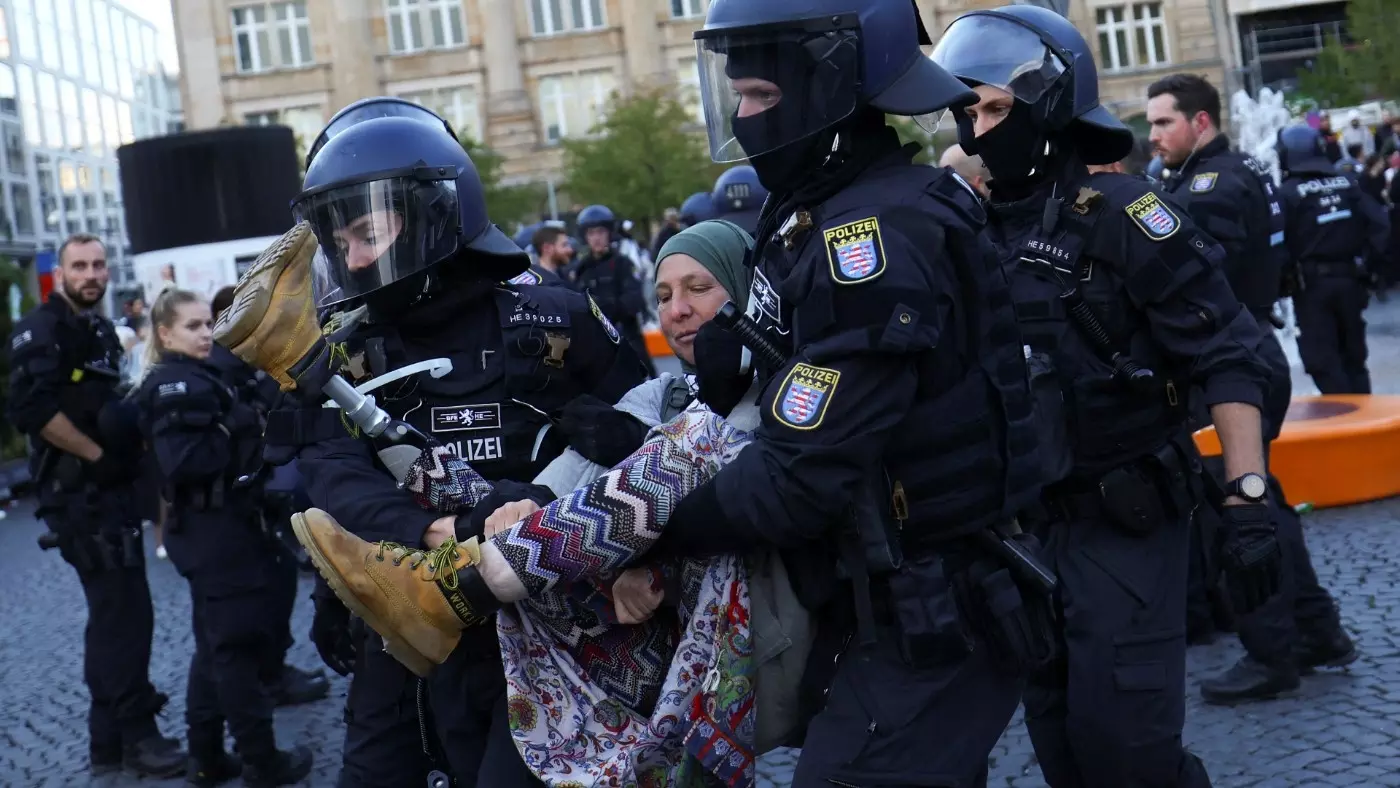 Police in Frankfurt lift a woman during a protest in solidarity with Palestinians on Saturday (Reuters)