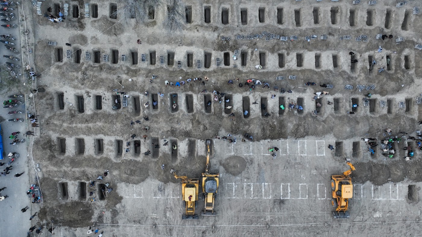 Mourners dig graves during a funeral for children killed in a reported strike on a primary school in Minab, Hormozgan province, Iran, on 3 March 2026 (Iranian Press Center/AFP)