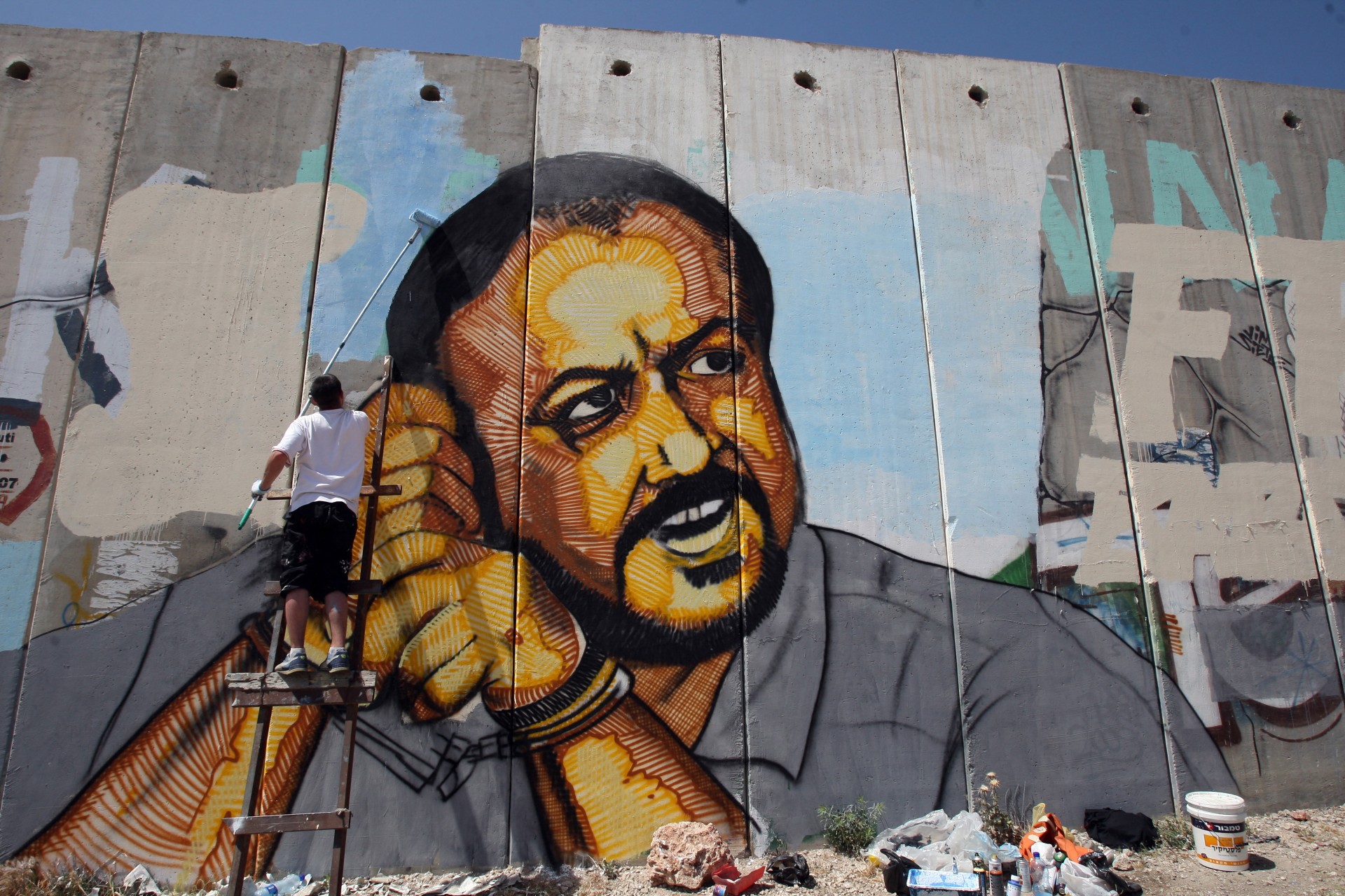 A Palestinian artist finishes a big portrait of jailed Palestinian Fatah leader Marwan Barghuti, between Jerusalem and Ramallah in the occupied West Bank on 12 May 2010 (AFP/Abbas Momani)