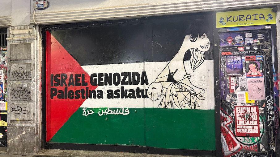 A mural painted on a storefront in Bilbao reads: 'Israel is committing a genocide. Free Palestine' (Azad Essa/MEE)