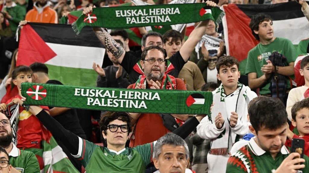 Fans hold up scarves and Palestinian flags during the friendly football match between Basque Country and Palestine at San Mamés Stadium in Bilbao on 15 November 2025 (Ander Gillenea/AFP)