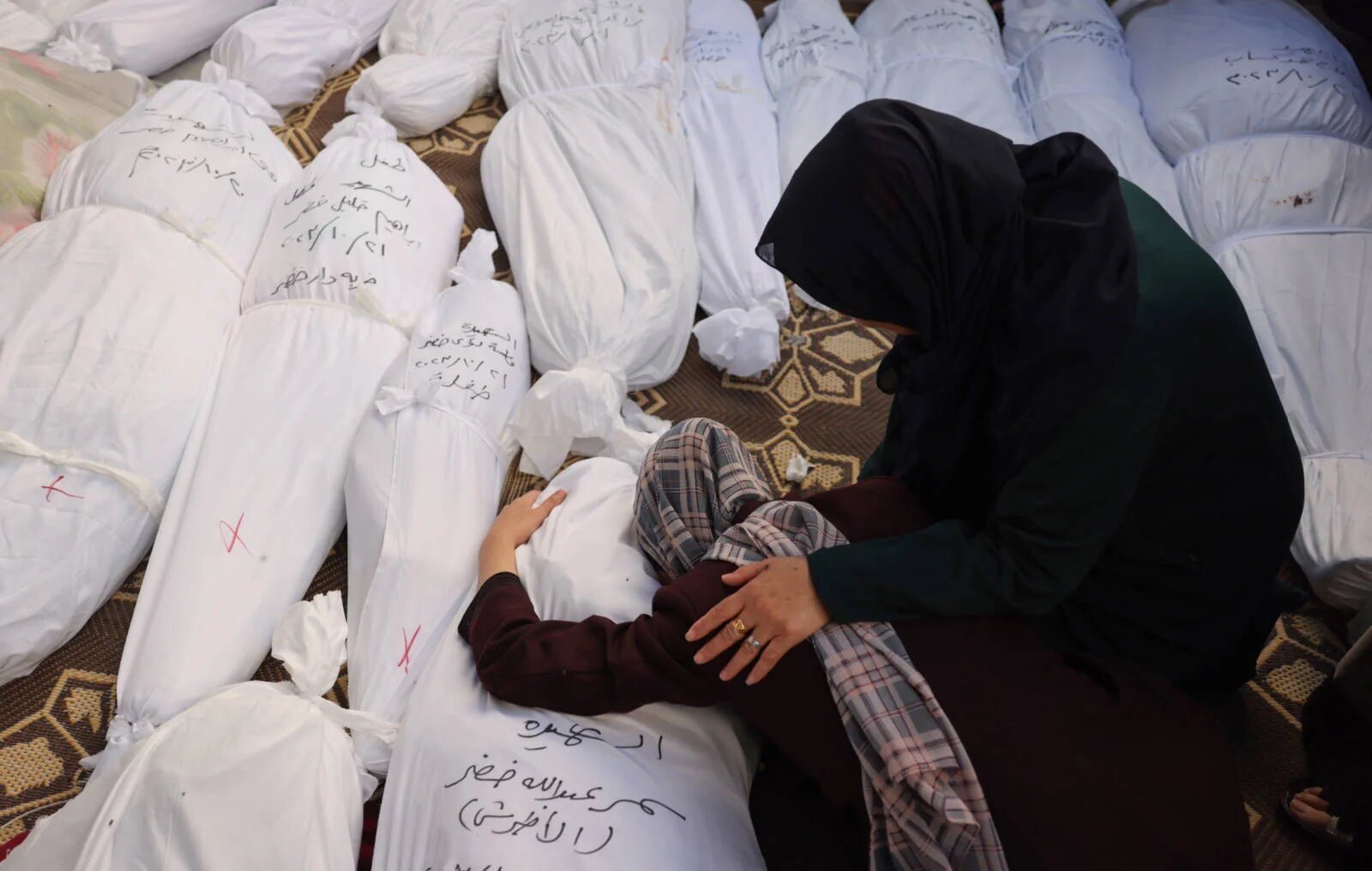 A woman mourns her sister, killed in an Israeli strike in Rafah on 21 October, 2023 (AFP)