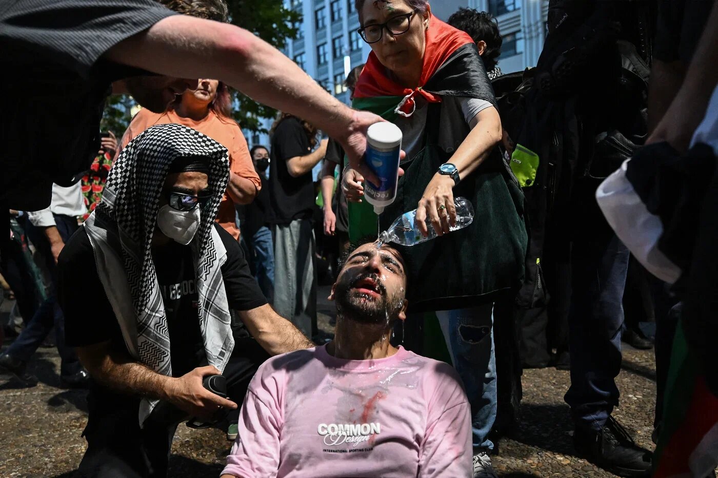 A protester is helped after police deployed pepper spray at a pro-Palestinian rally in Sydney, Australia on 9 February 2026 (Saeed Khan/AFP)