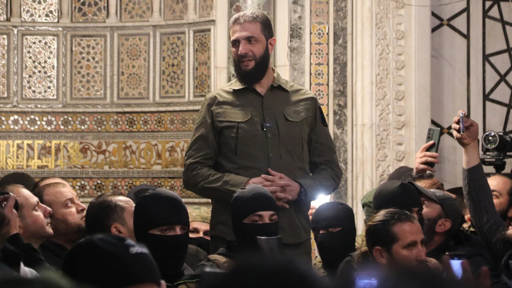 Abu Mohammed al-Jolani, addresses a crowd at the capital's landmark Umayyad Mosque on 8 December 2024 (AFP)