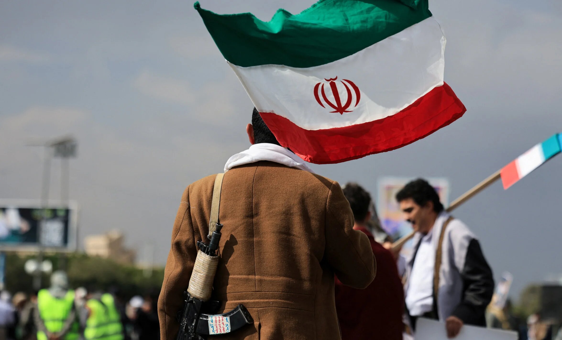 A person walks with an Iranian flag during a protest against Israeli and the US strikes on Iran, following the killing of Supreme Leader Ali Khamenei, in Sanaa, 1 March 2026 (Reuters/Khaled Abdullah)