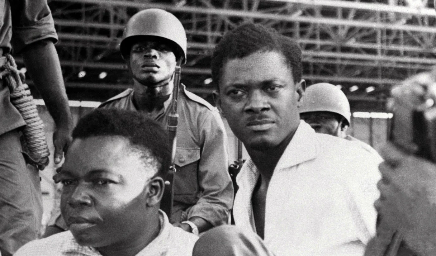 Soldiers guarding Patrice Lumumba, right, prime minister of then Congo-Kinshasa, and Joseph Okito vice-president of the senate in Leopoldville (now Kinshasa) in December 1960 (AFP)